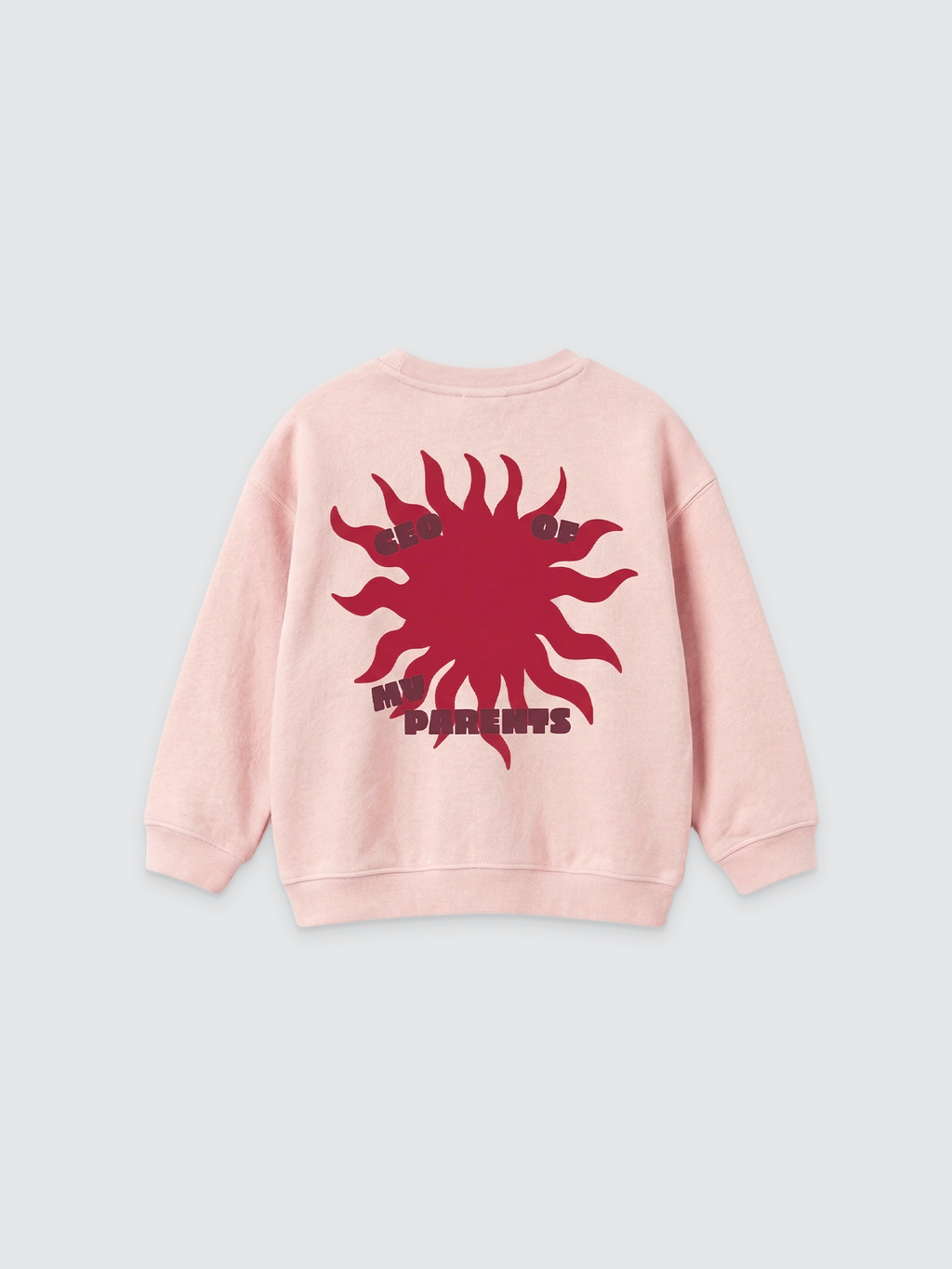 Ein hellrosa Kinder-Sweatshirt mit Rundhalsausschnitt und überschnittenen Schultern auf hellem Hintergrund. Auf dem Rücken befindet sich eine große dunkelrote Grafik einer stilisierten Sonne, in deren Mitte der Text „CEO OF MY PARENTS“ in Großbuchstaben steht.