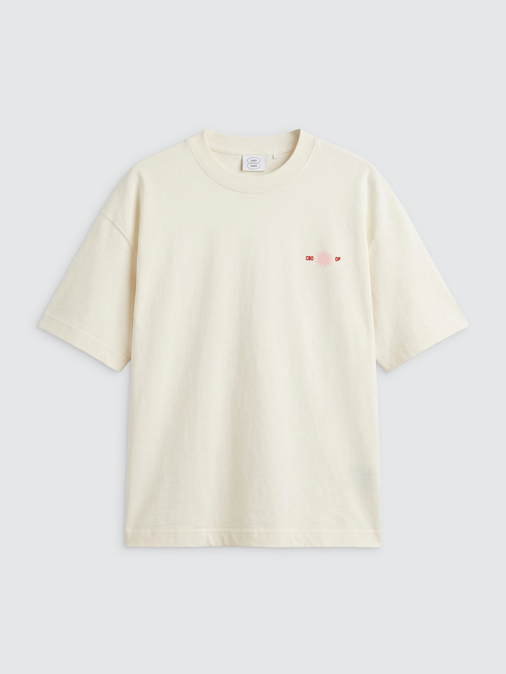 Vorderansicht eines cremeweißen Oversize-T-Shirts mit Rundhalsausschnitt. Auf der linken Brustseite befindet sich ein dezenter, kleiner Print: Eine hellrosa Sonne, flankiert von den roten Wörtern „CEO“ auf der linken und „OF“ auf der rechten Seite. Das Shirt hat weit geschnittene Ärmel und eine lockere Passform.