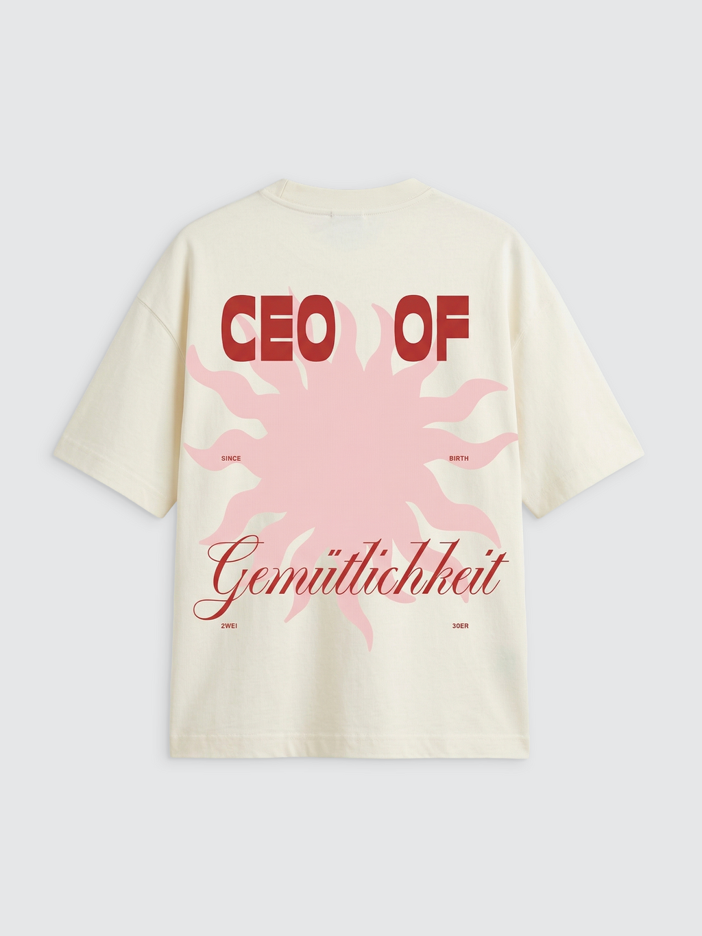 Rückansicht eines cremeweißen Oversize-T-Shirts mit einem großen Grafikprint. Im Zentrum steht eine große, hellrosa Sonne mit geschwungenen Strahlen. Darüber steht in fetten, roten Großbuchstaben „CEO OF“. Im unteren Drittel ist das deutsche Wort „Gemütlichkeit“ in einer eleganten, roten Schreibschrift platziert. Kleinere rote Textelemente wie „SINCE BIRTH“ und „2WEI 30ER“ flankieren die Grafik.