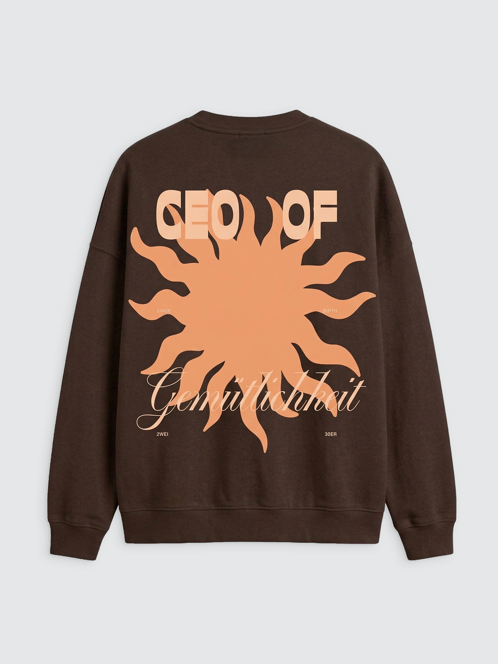 Rückansicht eines dunkelbraunen Oversize-Sweatshirts mit einem großflächigen Grafikprint. Das Design zeigt eine zentrale, pfirsichfarbene Sonne mit wellenförmigen Strahlen. Über der Sonne steht in großen, blockartigen Buchstaben in der gleichen Farbe der Schriftzug „CEO OF“. Im unteren Bereich verläuft das Wort „Gemütlichkeit“ in einer eleganten, hellbeigen Schreibschrift. Kleine Textzusätze wie „SINCE BIRTH“ und „2WEI 30ER“ ergänzen das Motiv an den Seiten.