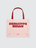 Eine hellrosa Canvas-Tote-Bag mit roten Henkeln. Auf der Vorderseite mittig ein großer, roter Schriftzug „SCHLEPPERELLO“ in einer fetten, leicht abgerundeten Blockschrift, der auf zwei Zeilen aufgeteilt ist. Am unteren Rand befinden sich drei kleinere rote Textelemente: In der Mitte steht „DINGE AUS DEM ALLTAG SCHLEPPEN“, flankiert von zwei kleinen ovalen Logos mit der Aufschrift „2WEI 30ER“.